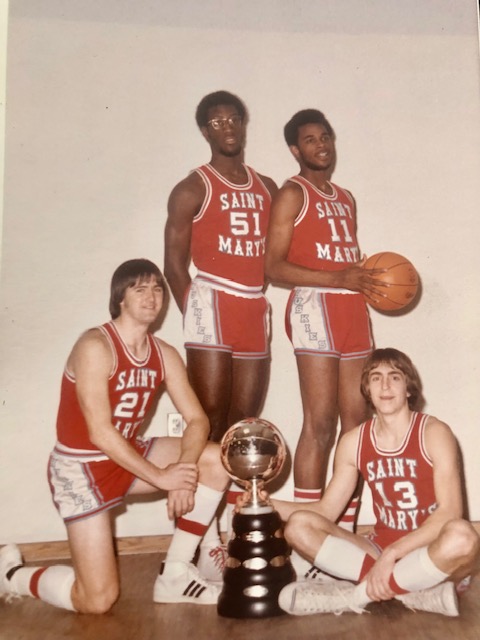Four Saint Mary's Huskies players posed with a championship trophy