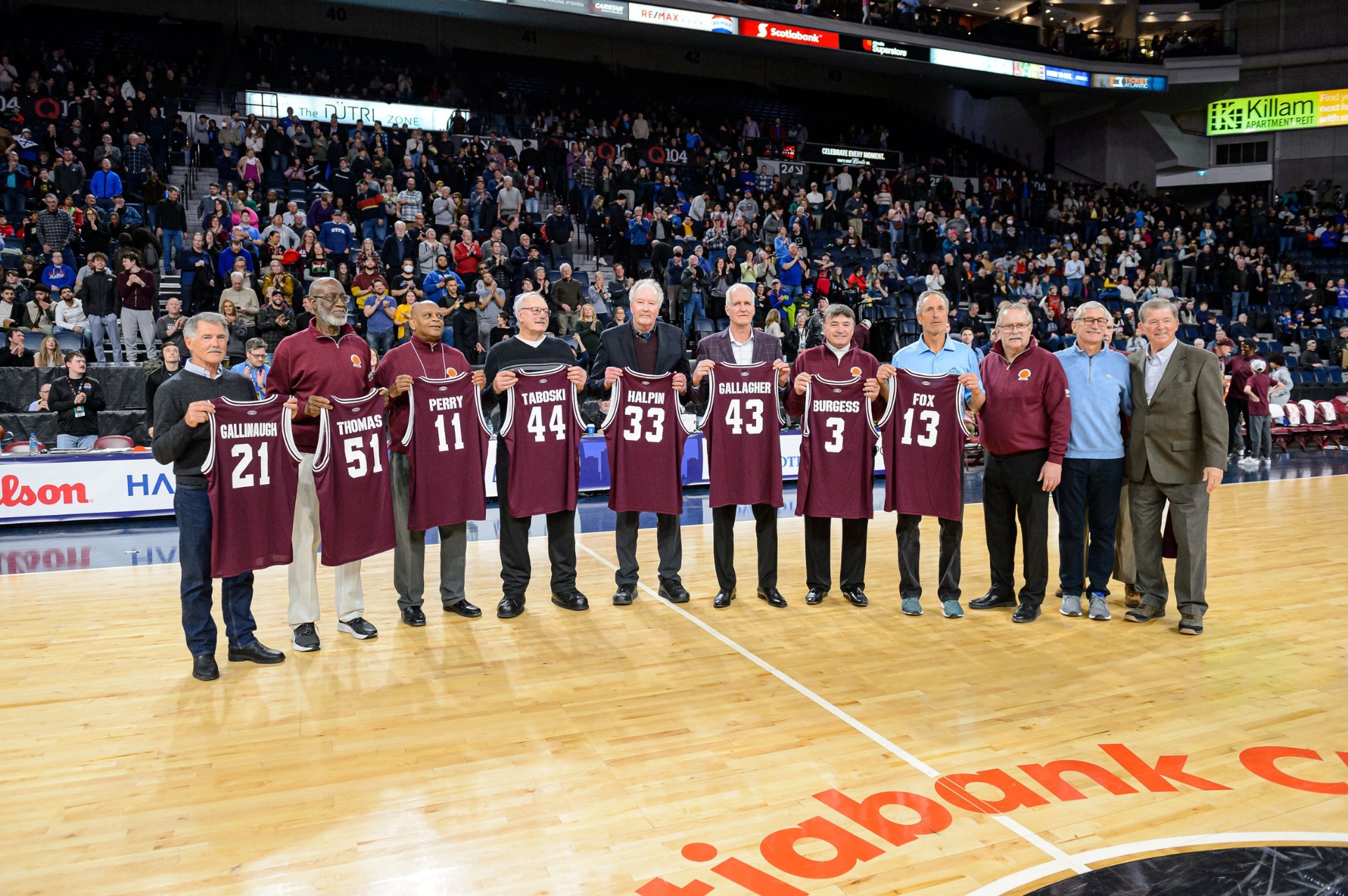 Saint Mary's championship alumni honoured at centre court holding their jerseys